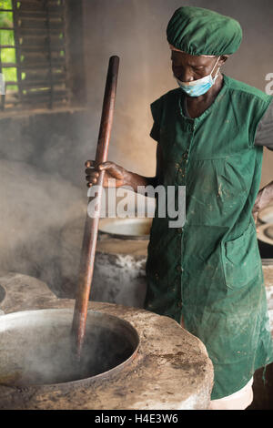 Les processus d'un employé dans l'huile de beurre de karité du commerce équitable à un site de production à réo, Burkina Faso, Afrique de l'Ouest. Banque D'Images