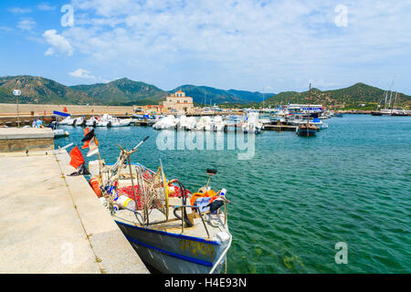 PORT DE PORTO GIUNCO, Sardaigne - 25 MAI 2014 : bateau de pêche et net sur la rive en Porto Giunco, port touristique de l'île de la Sardaigne, Italie. De nombreux touristes visitent l'île de la Sardaigne dans l'heure d'été. Banque D'Images