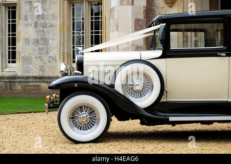 D'un côté, vue de face d'un Classic, vintage vieille voiture de Ford, ornés de rubans de mariage et garé sur une allée en gravier Banque D'Images