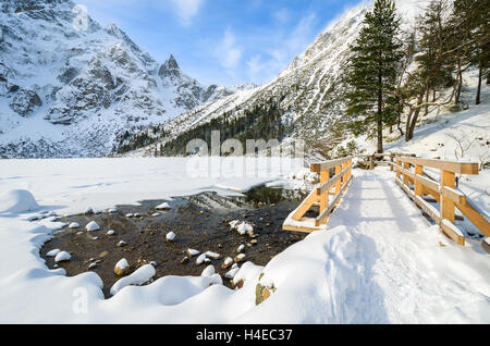 Passerelle en bois sur le sentier de randonnée et couverte de neige belle en hiver le lac Morskie Oko, Hautes Tatras, Pologne Banque D'Images