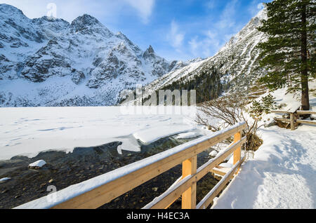 Passerelle en bois sur le sentier de randonnée et couverte de neige belle en hiver le lac Morskie Oko, Hautes Tatras, Pologne Banque D'Images