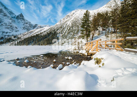 Passerelle en bois sur le sentier de randonnée et couverte de neige belle en hiver le lac Morskie Oko, Hautes Tatras, Pologne Banque D'Images