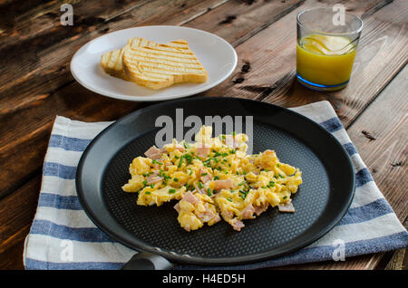 Oeufs brouillés avec du pain grillé et donut sur bois Banque D'Images