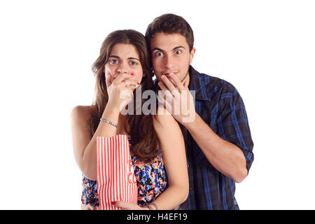 Portrait of young beautiful couple regardant un film effrayant et eating popcorn. Isolé sur fond blanc. Banque D'Images