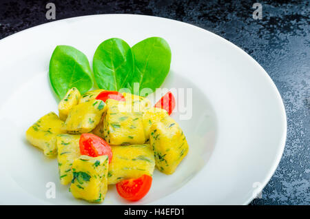 Gnocchi aux épinards avec du beurre fondu et les tomates cerise du jardin Banque D'Images