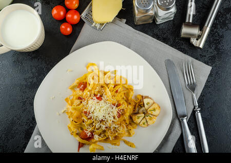 Des tagliatelles aux tomates cerises et ail grillé bio Banque D'Images