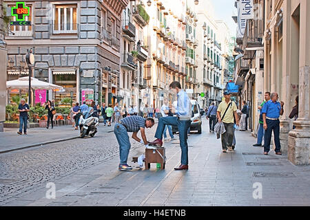 Un homme nettoie les chaussures sur la Via Toledo, la ville centrale street, à côté de la galerie Umberto I, Naples, Italie Banque D'Images