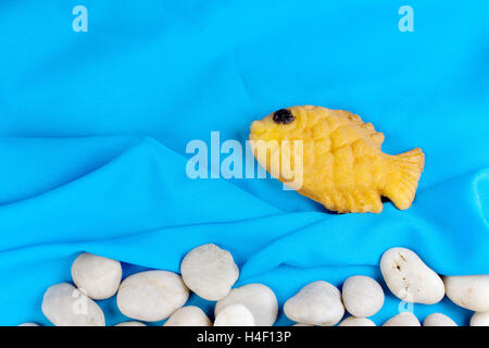 Taiyaki, japonais en forme de poisson sur crêpe chiffon bleu et rock-arrondies. Banque D'Images