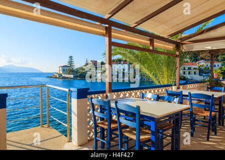Chaises bleues avec des tables de taverne grecque traditionnelle à Fiskardo port, l'île de Céphalonie, Grèce Banque D'Images