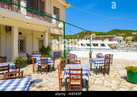 Chaises avec tables de restaurant grec traditionnel au port de Vathy, Ithaka island, Grèce Banque D'Images