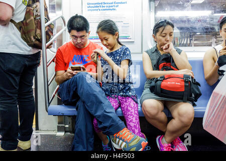 New York City,NY NYC,Queens,métro,train,MTA,transports en commun,train,passagers passagers rider riders,assis,Asian Asian ethnigigran Banque D'Images