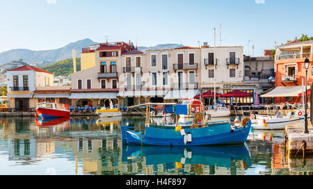 Les bateaux de pêche colorés sont amarrés dans le vieux port, à côté de la minuscule cafés et tavernes, Rethymno, Crète, Grèce. Banque D'Images