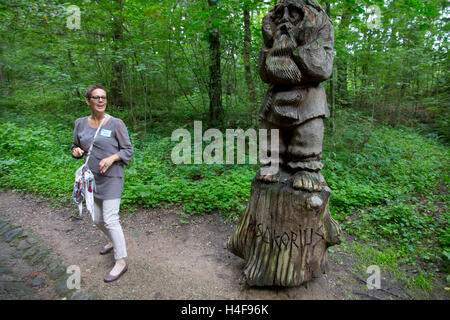 Un guide local conduit les visiteurs dans une visite de la Colline des Sorcières, site d'un assemblage de plus de 80 mâts-comme des sculptures. Banque D'Images