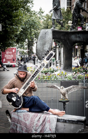 Les amuseurs publics de la lecture d'un grand Pro sitar indien Tun un instrument Abington Street, Northampton Town Centre. Banque D'Images