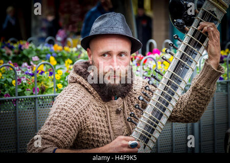 Les amuseurs publics de la lecture d'un grand Pro sitar indien Tun un instrument Abington Street, Northampton Town Centre. Banque D'Images