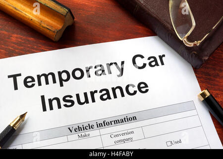 Formulaire de demande d'assurance voiture temporaire sur une table. Banque D'Images