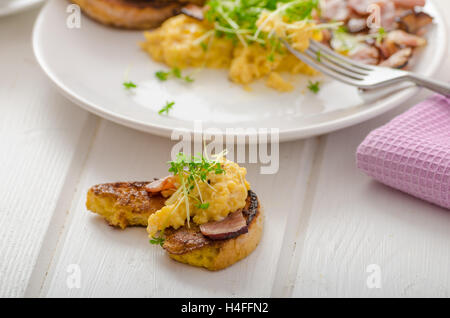 Oeufs brouillés avec du pain doré garni de cresson frais microgreens, eau d'orange Banque D'Images