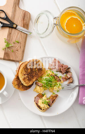 Oeufs brouillés avec du pain doré garni de cresson frais microgreens, eau d'orange Banque D'Images