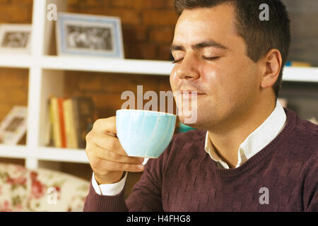 Jeune homme de boire du café, thé ou chocolat Banque D'Images