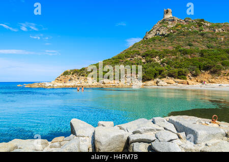 Deux ou trois personnes non identifiées la natation dans la mer d'azur bay près de Torre de Porto Giunco, tour de l'île de la Sardaigne, Italie Banque D'Images