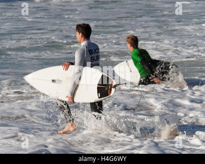 Les candidats à la compétition de surf étudiante dans les grandes vagues de soleil à la plage de Fistral Newquay, Cornwall. Banque D'Images