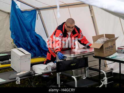 Celle, Allemagne. 16 Oct, 2016. Un assistant de Johanniter de Finlande travaille dans une tente lors d'une pratique de l'aide à l'étranger Johannieter dans Celle, Allemagne, 16 octobre 2016. Les missions plus complexes et la formation avancée, comme ordonné par la loi - c'est ainsi qu'elle porte sur des services de secours. Il n'y a pas de manque d'aidants en Basse-Saxe. Mais cela pourrait changer rapidement, en tant que représentants Johanniter mise en garde. PHOTO : PETER STEFFEN/dpa/Alamy Live News Banque D'Images