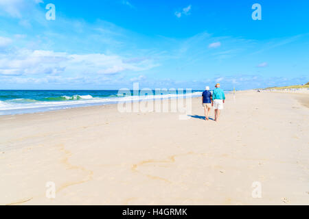 Couple non identifié de personnes âgées marcher le long de la mer sur une belle plage de sable, l'île de Sylt, Allemagne Banque D'Images