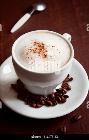 Tasse de cappuccino avec cacao garniture sur fond rustique en bois foncé Banque D'Images