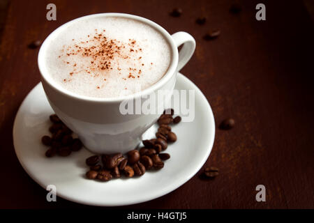 Tasse de cappuccino avec cacao garniture sur fond rustique en bois foncé Banque D'Images