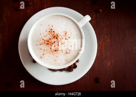 Tasse de cappuccino avec cacao garniture sur fond rustique en bois foncé Banque D'Images