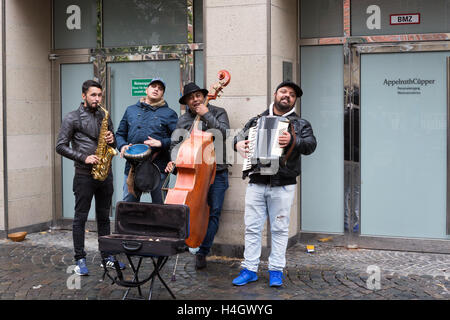 Quatre musiciens d'apparence moyen-orientale instruments jouent dans la rue en Allemagne Banque D'Images