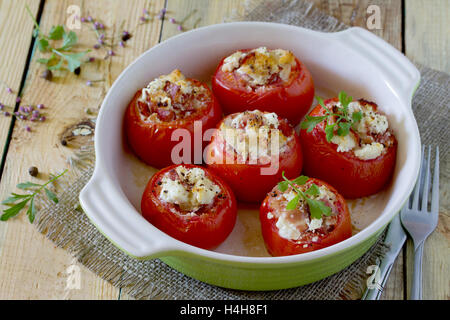 Tomates farcies au four avec du bacon et fromage feta sur table rustique Banque D'Images