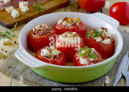 Tomates farcies au four avec du bacon et fromage feta sur table rustique Banque D'Images