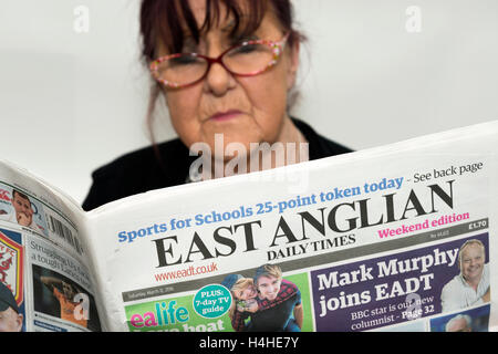 Femme lisant un exemplaire de l'East Anglian Daily Times newspaper Banque D'Images