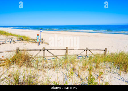 Jeune femme debout à l'entrée touristique belle plage de sable en Lubiatowo village côtier, mer Baltique, Pologne Banque D'Images