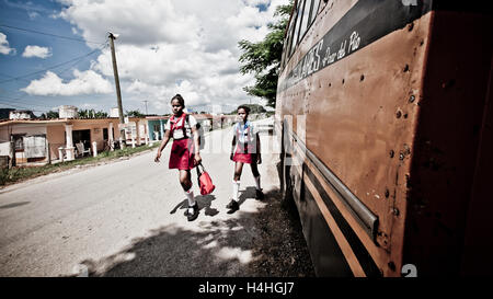 Deux jeunes filles de l'école cubaine à pied à la maison de l'école dans leurs uniformes scolaires à Viñales, Cuba. Banque D'Images