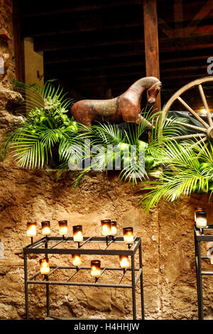 Plein de candélabre allumé des bougies dans un château avec des plantes et des pétale de rose eau du bain Banque D'Images