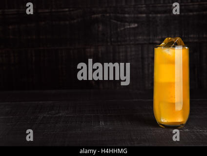 Verre de soda à l'orange avec des cubes de glace sur fond de bois Banque D'Images