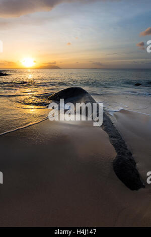 Coucher de longue exposition tiré sur Sunset Beach au nord de Mahe, Seychelles de rochers en premier plan Banque D'Images