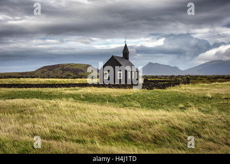 Décor d'église en bois noir de Budir en Islande avec les pâturages et les montagnes en arrière-plan Banque D'Images
