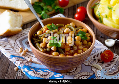 La saine alimentation, l'alimentation, la cuisine végétarienne et la cuisine concept - compotée de pois chiches à la tomate, l'ail et les haricots verts. Po bouilli Banque D'Images