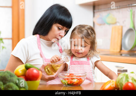 L'enseignement de mère enfant faisant salade en cuisine. Concept de cuisine de famille heureuse de préparer des aliments pour le dîner. Banque D'Images