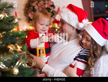 Heureux père et mère avec bébé près de l'arbre de Noël
