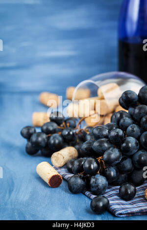 Succursale de purple Grape and Wine corks sur la table avec plateau en verre et la bouteille sur arrière-plan Banque D'Images