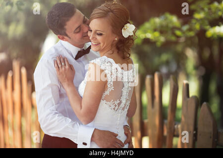 Belle mariée et le marié baiser en plein air après le mariage Banque D'Images