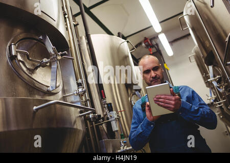 Propriétaire à l'aide de l'ordinateur tablette à Brewery Banque D'Images