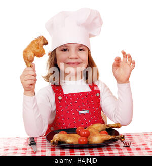 Petite fille cook avec pilons de poulet Banque D'Images