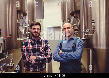 Propriétaire confiant avec commandes de machines au milieu de travail Banque D'Images