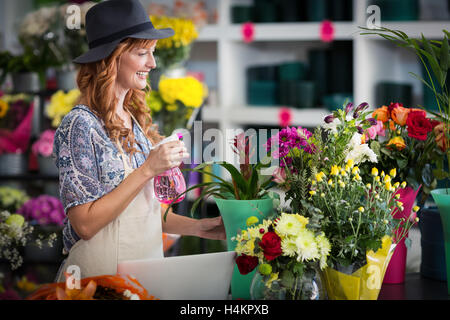 Les fleuristes, pulvériser de l'eau sur les fleurs dans le magasin de fleurs Banque D'Images