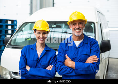 Portrait de warehouse workers standing avec les bras croisés Banque D'Images